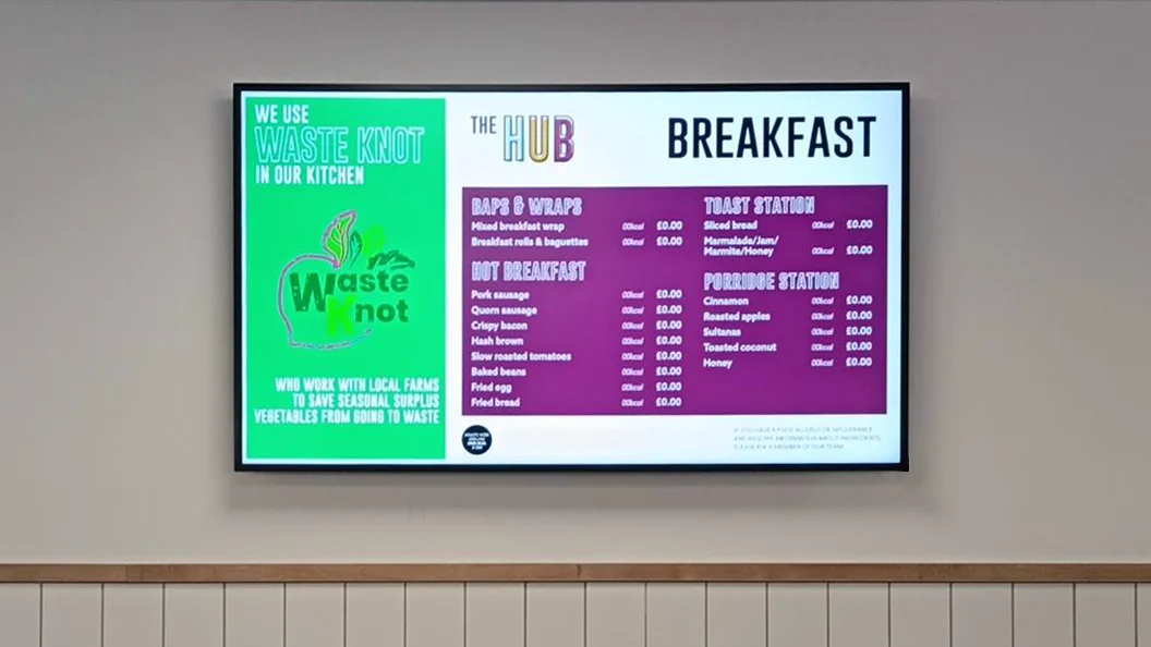 Close up of a digital menu board showing menu items and internal comms.
